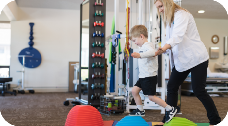 Pediatric physical therapist guiding a child through movement exercises