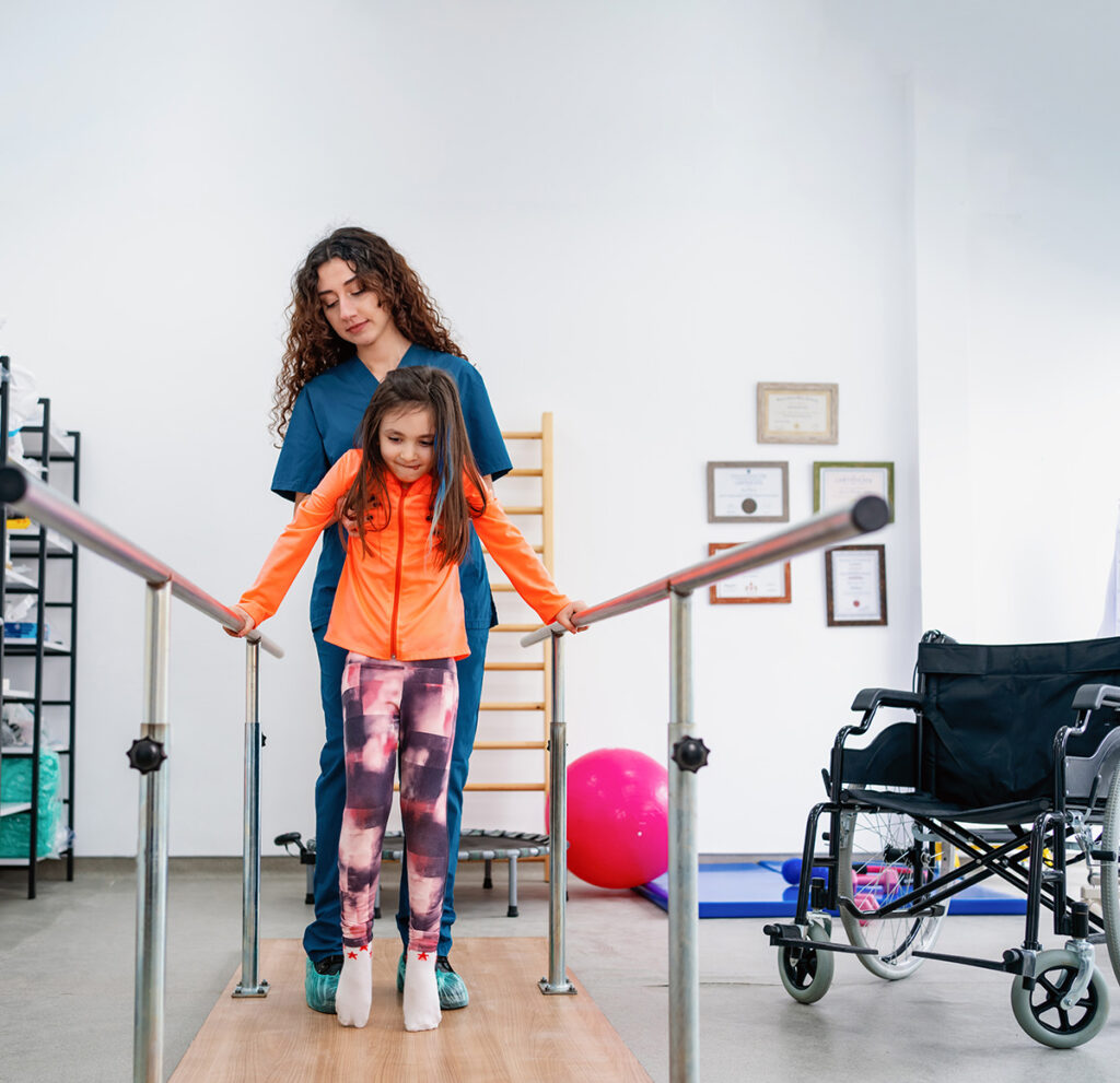 Fisioterapeuta pediátrico ayudando a un niño con el equilibrio y la motricidad gruesa